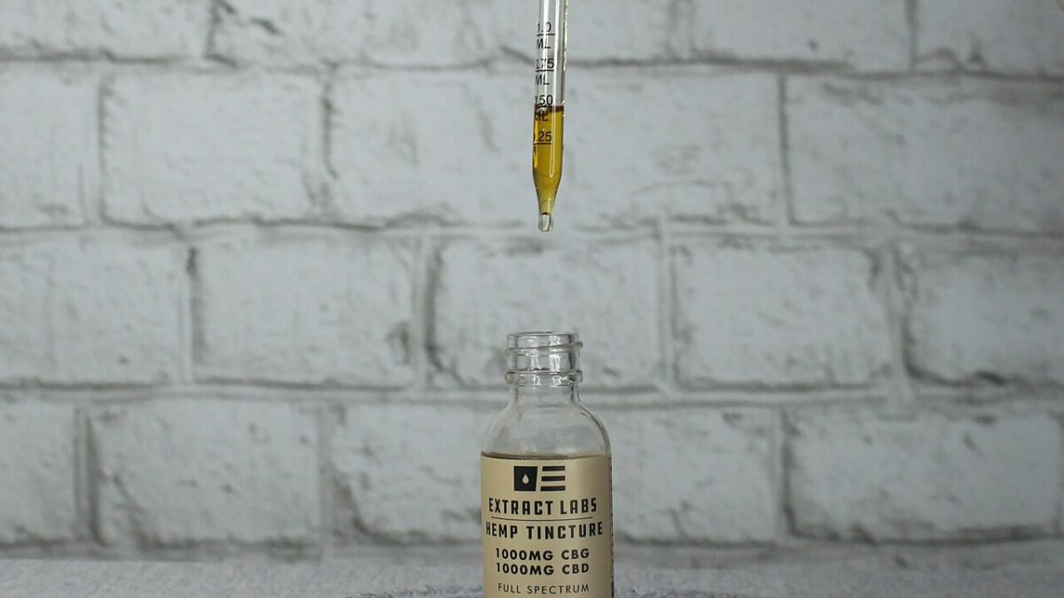 Flacon d'huile de CBD et pipette tenue au-dessus