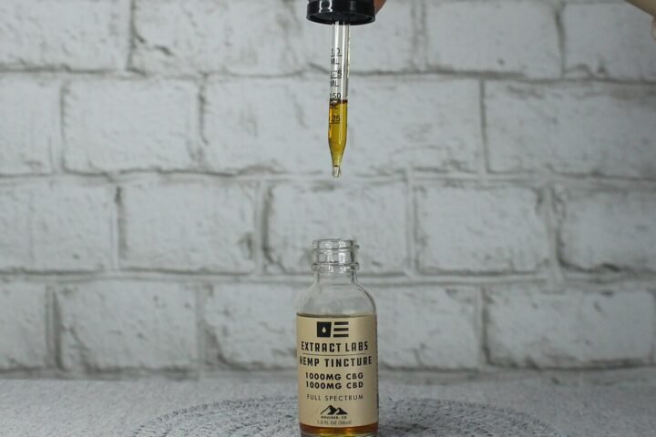 Flacon d'huile de CBD et pipette tenue au-dessus