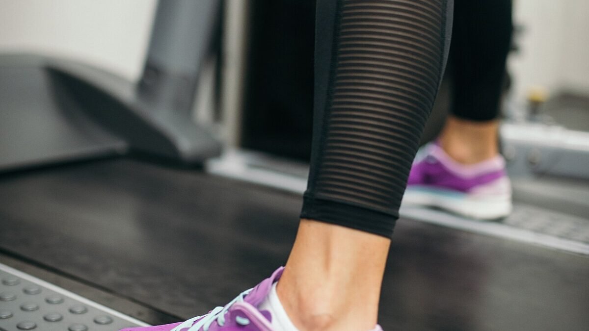 Gros plan sur les jambes d'une personne courant sur un tapis de course