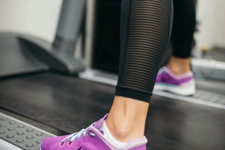 Gros plan sur les jambes d'une personne courant sur un tapis de course