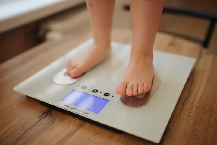 Pieds nus sur une balance électronique blanche