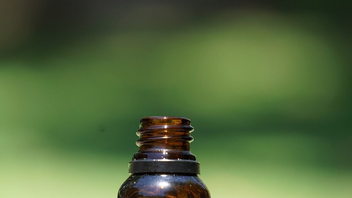 Flacon ambré d'huile de CBD posé dans l'herbe