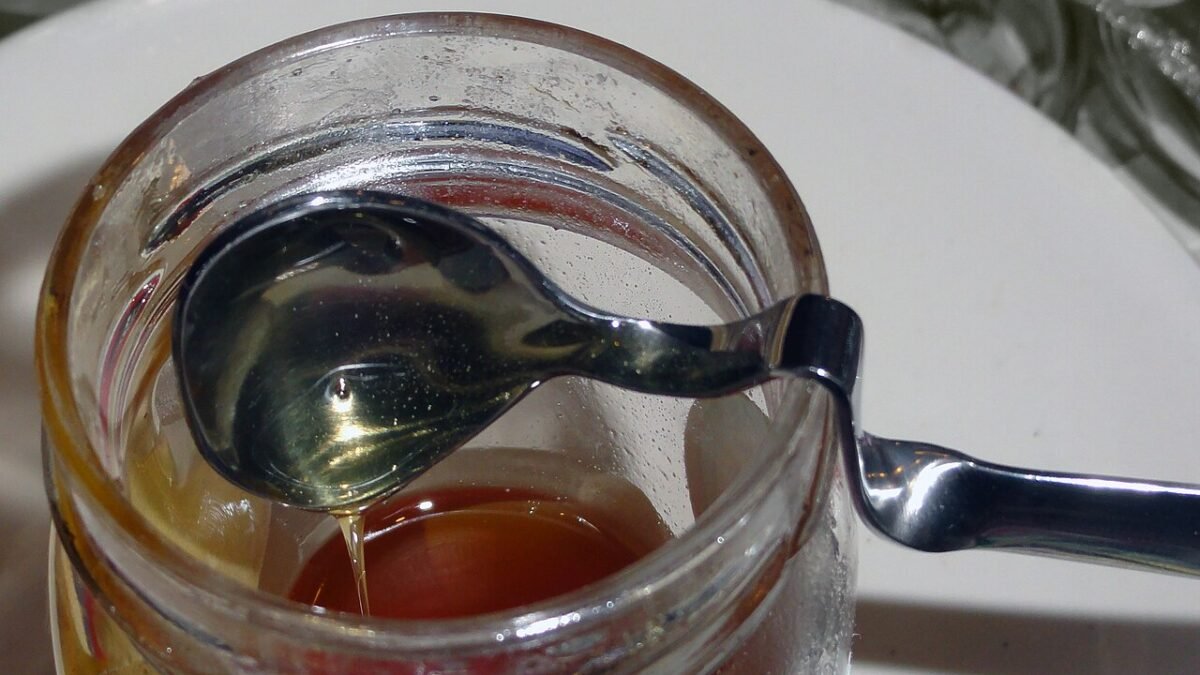 Cuillère plongée dans un pot de miel