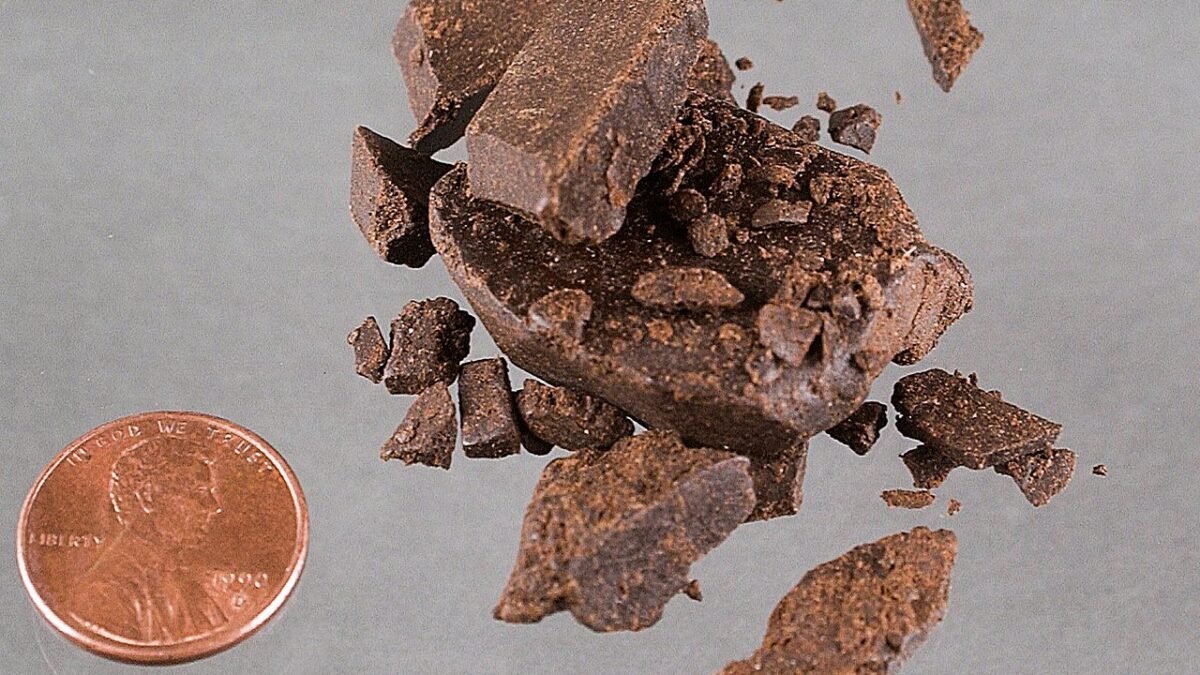 Morceaux de résine de chanvre brun clair à côté d'une pièce de monnaie