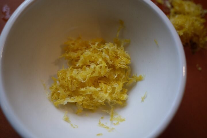 Zestes de citron râpés dans un bol blanc