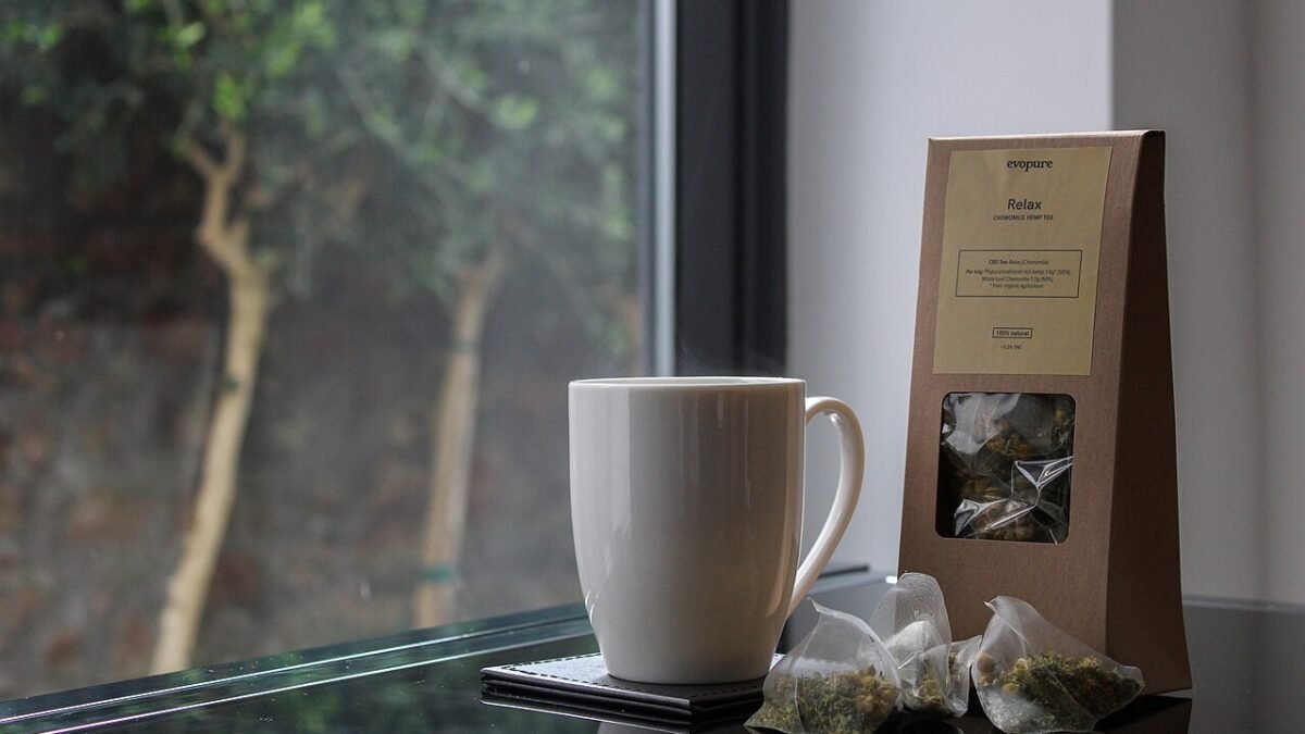 Tasse et sachets d'infusion au chanvre devant une fenêtre
